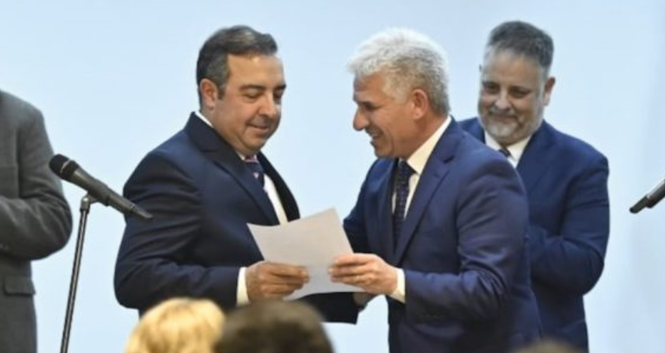 Alfonso Vergés, ministro de Ciencia y Tecnología, recibe el decreto de designación de manos del gobernador, Claudio Poggi.